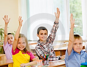 Children raising hands knowing the answer to the question