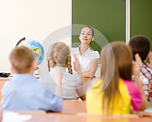 Children raising hands knowing the answer to the question