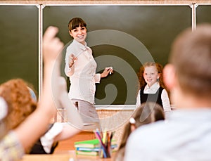 Children raising hands knowing the answer to the question photo