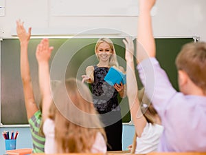 Children raising hands knowing the answer to the question