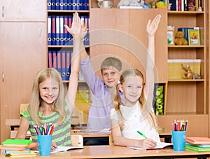 Children raising hands knowing the answer to the question