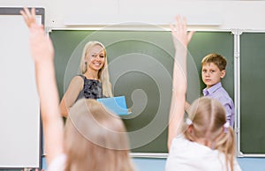 Children raising hands knowing the answer to the question