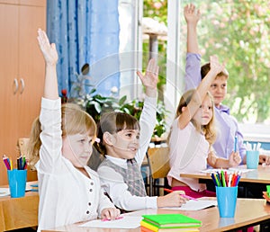 Children raising hands knowing the answer to the question photo