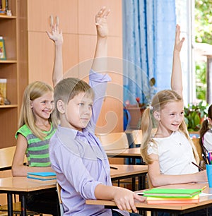 Children raising hands knowing the answer to the question photo