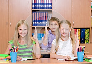 Children raising hands knowing the answer to the question photo