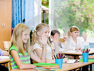 Children raising hands knowing the answer to the question