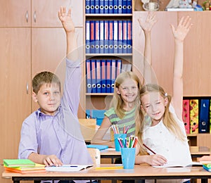 Children raising hands knowing the answer to the question