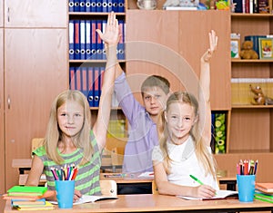 Children raising hands knowing the answer to the question photo