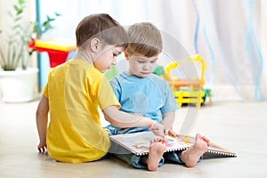 Children read a book sitting on floor at home