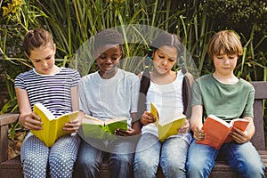 Children reading books at park