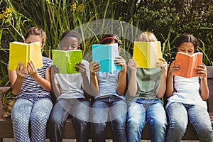 Children reading books at park