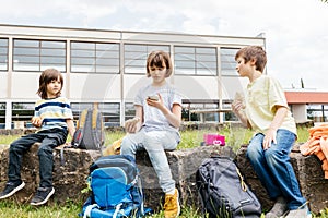 Children at recess sit in the schoolyard and eat sandwiches and apples. Snack while studying.