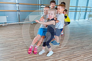 Children and recreation, group of happy multiethnic school kids playing tug-of-war with rope in gym