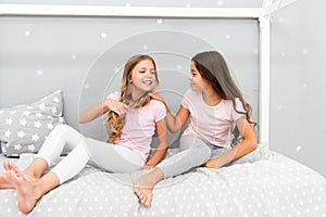 Children relax and having fun in evening. Sisters leisure. Girls in cute pajamas spend time together in bedroom. Sisters