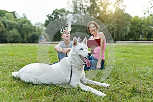 Children rest in the park with a dog