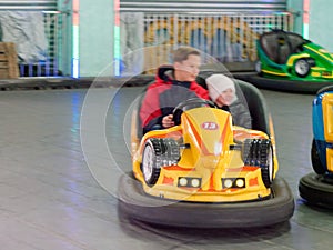 Children ride a children`s amusement ride electric cars