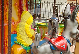 Children ride on the horses on the colorful carousel in the Park