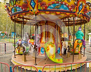 Children ride on the horses on the colorful carousel in the Park