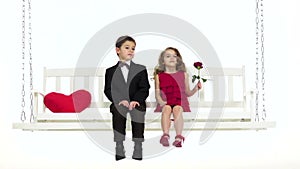 Children ride on a swing, they have a romantic relationship. White background. Slow motion