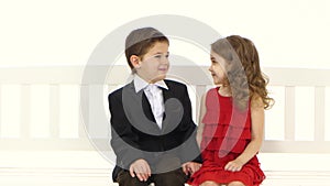 Children ride on a swing, kiss each other on the cheek. White background