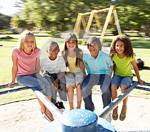 Children Riding On Roundabout In Playground