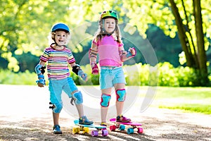 Children riding skateboard in summer park