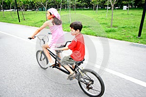 Children riding on a tandem bike.