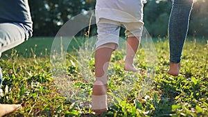 children run in the park. bare feet close-up group of children running on green grass in summer. happy family kid dream