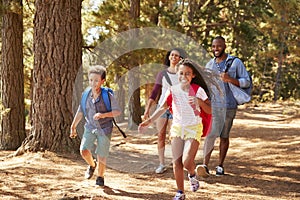 Children Running Ahead Of Parents On Family Hiking Adventure
