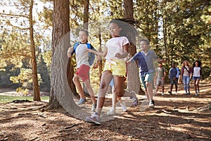 Children Running Ahead Of Parents On Family Hiking Adventure