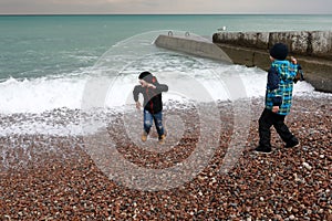 Children running away from wave on Gurzuf beach