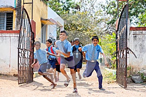 Children running out from school by opening gate after the bell - concept of education, freedom, happiness, enjoyment