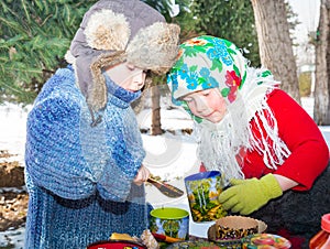 Children in Russian pavloposadskie scarf on head drinking tea on background of samovar.