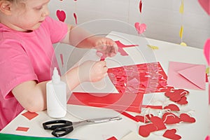 children& x27;s applications for valentine& x27;s day, the girl cuts out valentines and makes cards for the holiday