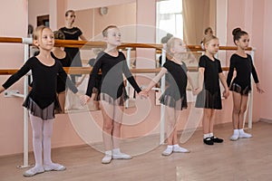 Children's ballet school. Caucasian woman teaching ballet to little girls.