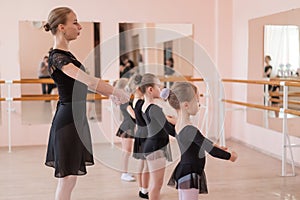 Children& x27;s ballet school. Caucasian woman teaching ballet to little girls.