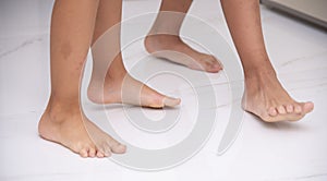 Children's bare feet. Child's bare feet on the white floor
