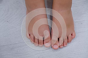 Children`s bare feet. Child`s bare feet on the wooden floor