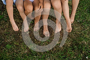 Children`s bare feet close-up on the lawn in the park