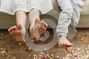 Children`s bare feet with confetti on their feet