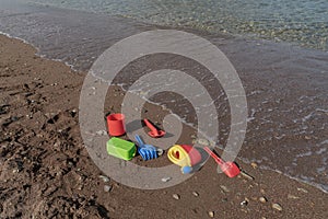 Children`s beach sand toys. Kids concept. Plastic children`s toys. Blue bucket, colorful molds. Kids toys, on sand beach in summ