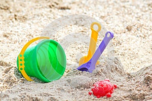 Children`s beach toys - buckets, spade and shovel on sand on a sunny day