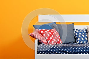 Children`s bed with different color pillows