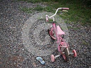 Children`s bikecycle and shoe on stone road. missing children co