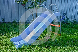 Children`s blue plastic slide installed in the courtyard