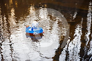 Children`s boat blue goes on the golden water