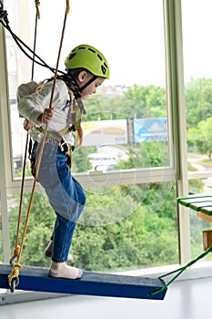 Children's cableway in the playroom, little girl passes the cableway.