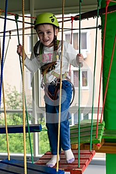 Children's cableway in the playroom, little girl passes the cableway.