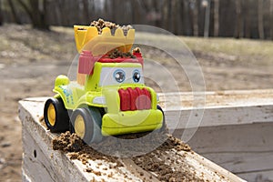 Children`s car in the sandbox. Spring. sandbox