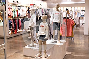 Children`s clothing on mannequins, on hangers in stores. The concept of shopping